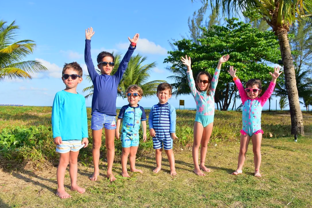 Grupo de crianças com roupas Pulpo brincando ao ar livre perto da praia